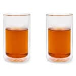 Mooie cocktail glaasjes met amberkleurige drank, perfect voor feestelijke gelegenheden of borrels. Modern en stijlvol design, ideaal voor evenementen van De Heeren van 17.