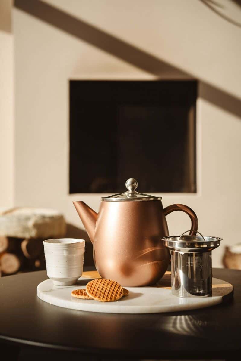 Rookkan, thee, en koek op een houten dienblad, ontspannen sfeer, gezellige theesessie, vintage stijl, stijlvolle kop en theepot, warm licht, modern interieur, comfortabel setting, de Heeren van 17.