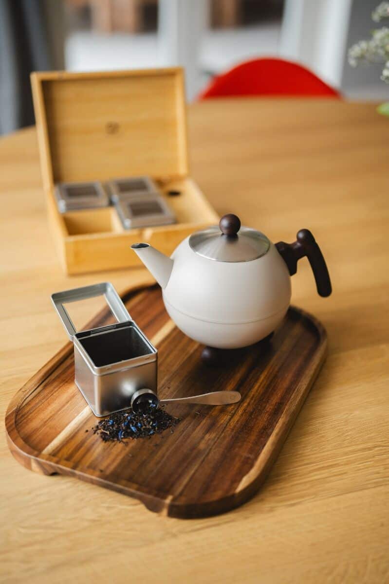 Geurthee en thee op een houten dienblad met een theepot, suiker en thee-ei, stijlvolle theeservice, perfect voor genieten van een kop thee bij De Heeren van 17.