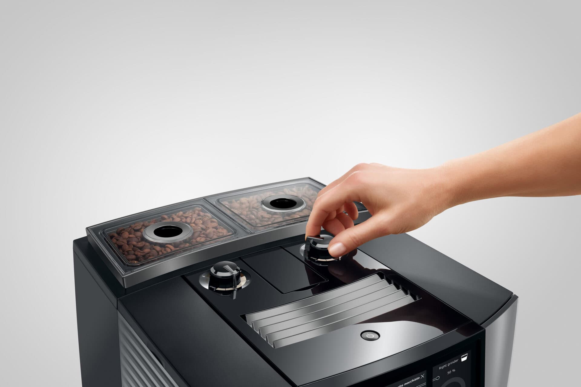 Kleine Hand die de instellingen van een moderne koffiemachine bedient, close-up van het gebruik en de bediening.